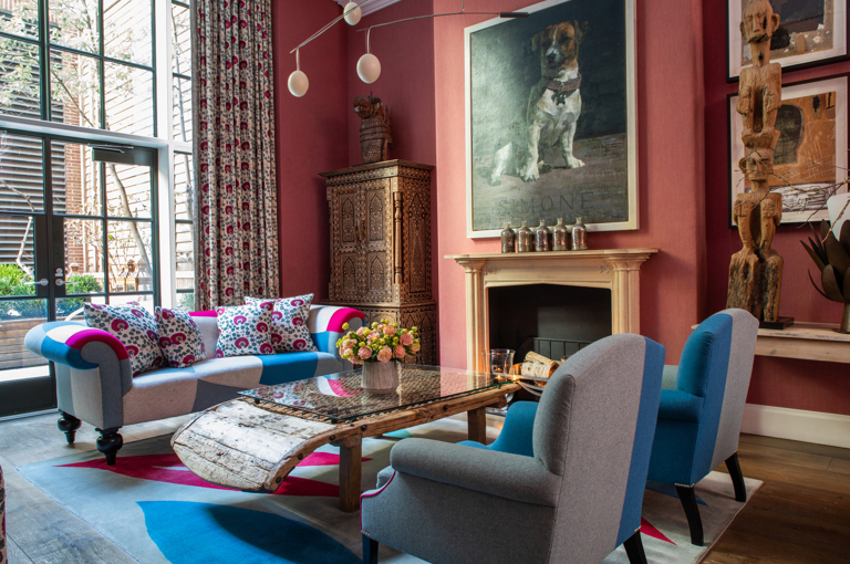 Diagonal shot of seating area around the fireplace the drawing room at Crosby Street Hotel.