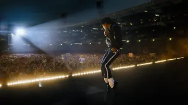 A still from the film "Michael": The image displays a singer on stage at a large stadium