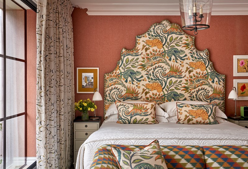 A room at Ham Yard Hotel with a large statement headboard and a sofa at the end of the bed