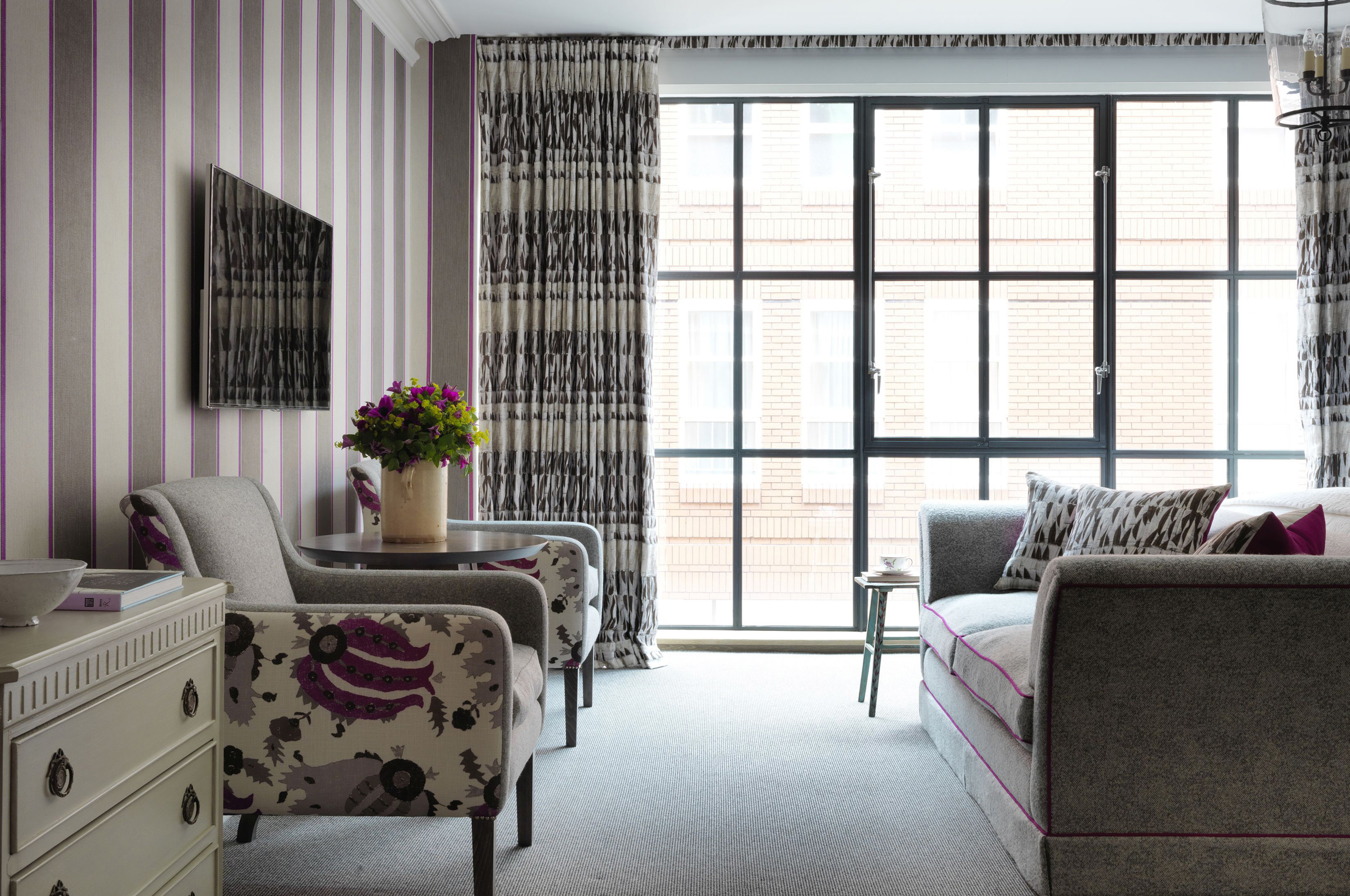 Elegant bedroom with striped walls, modern furnishings, city view