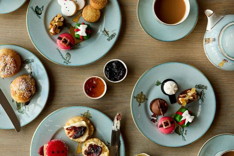 Festive Afternoon Tea shot from above. Cups of tea and plates of cakes and sandwiches laid on a table on Sailor's Farewell crockery 