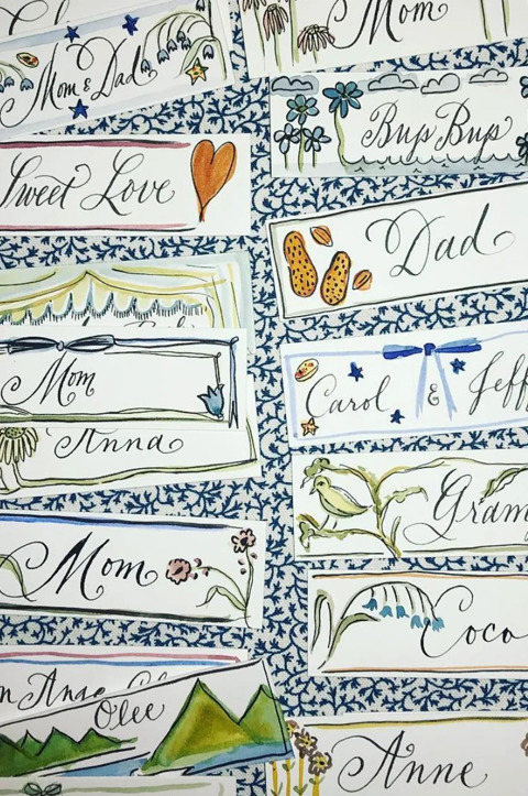 A collection of placecards with colourful illustrations and names written by calligrapher Stephanie Fishwick