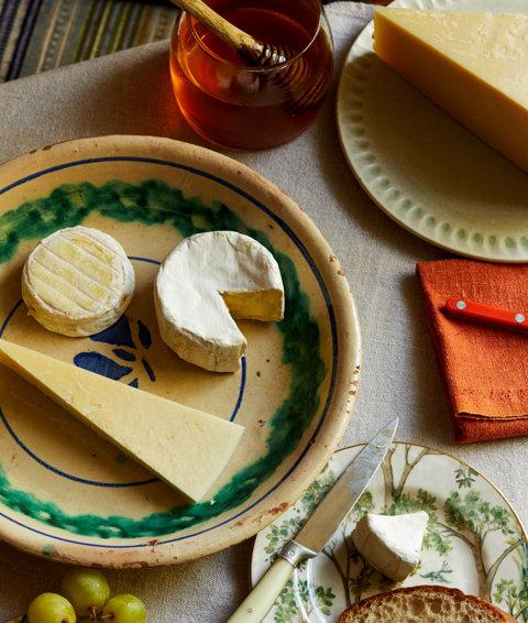 An close up image of a table with multiple different plates with cheeses at The Potting Shed, Dorset Square Hotel. 