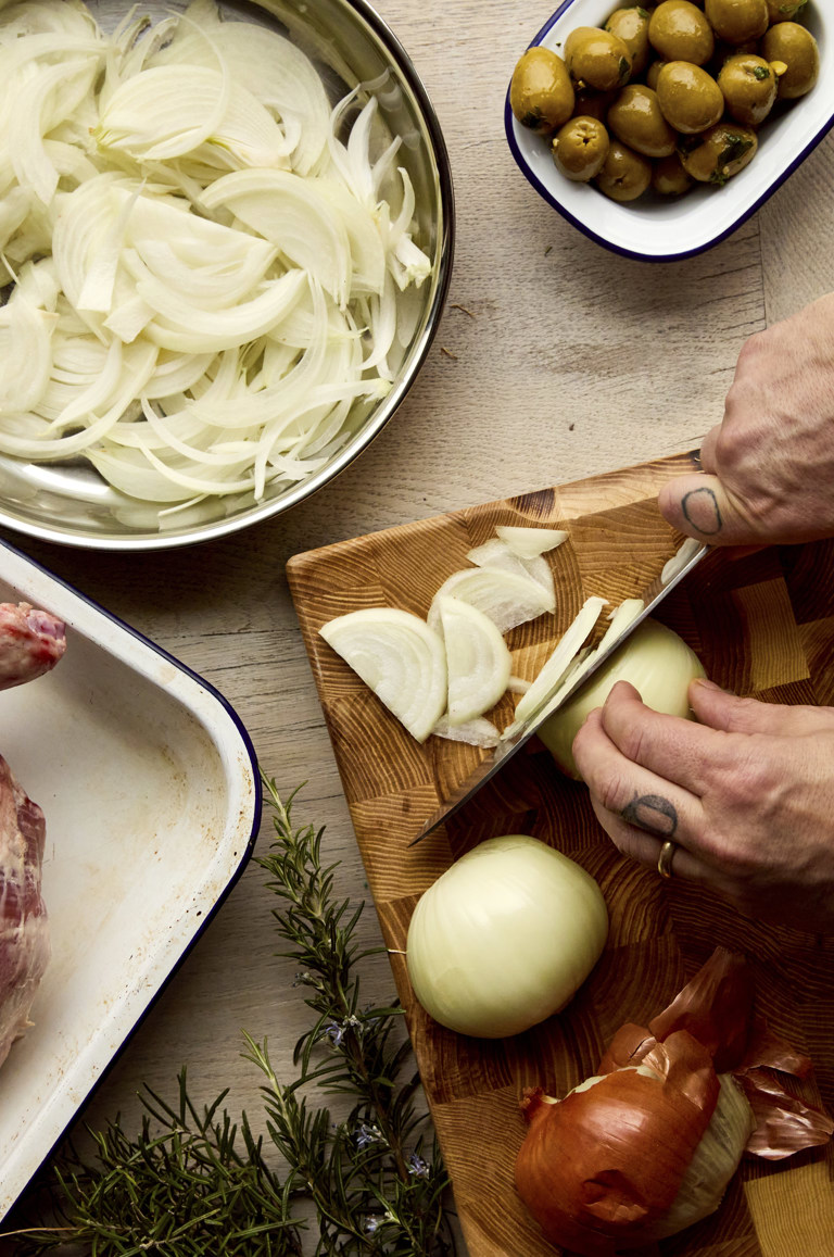 A portrait shot of onions being chopped on chopping board