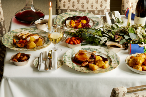 Wide shot of festive dining set-up with wine on Tall Trees bespoke crockery