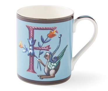 The purple cross hatched "f" on this pale blue mug forms a decorative background to the mythical winged creature, with its blue and yellow corn-like floral posy.