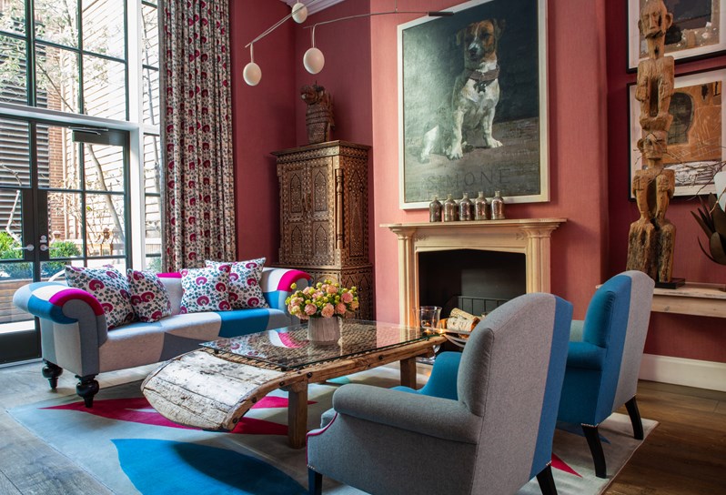 Diagonal shot of seating area around the fireplace the drawing room at Crosby Street Hotel.