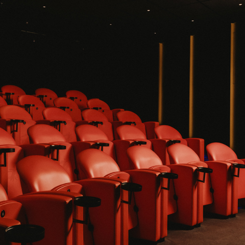 Diagonal shot across the red seating in the screening room at Covent Garden Hotel