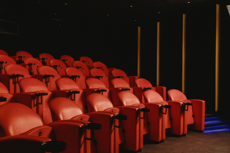 Diagonal shot across the red seating in the screening room at Covent Garden Hotel