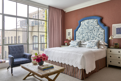 A wide angle shot of the bed area and view out of the windows in the Deluxe Junior Suite 601 at Crosby Street Hotel