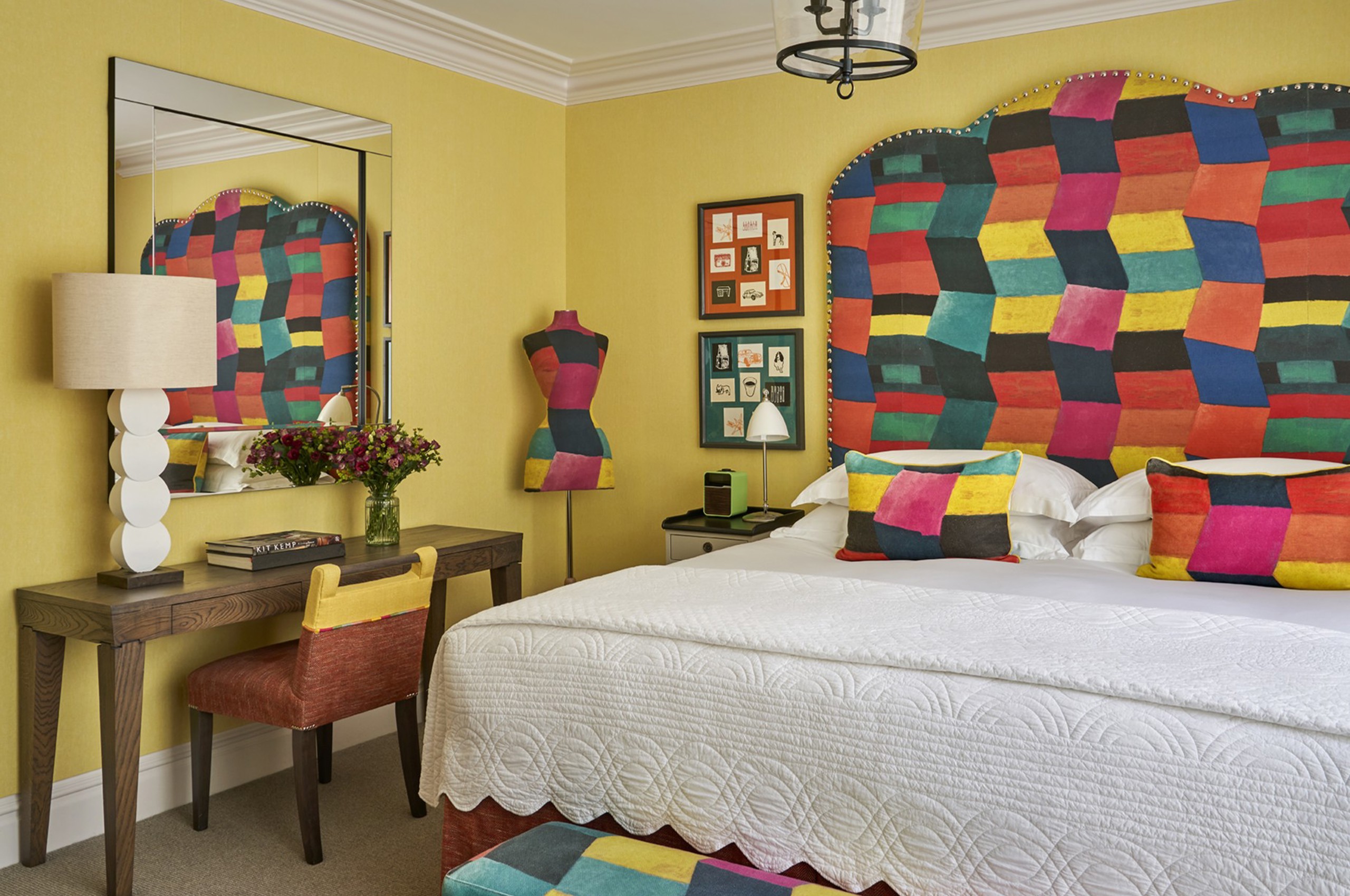 Colorful hotel bedroom with patterned headboard and desk