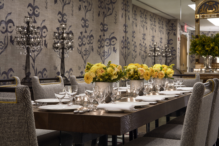 Close shot of a long dining table set-up with dim lighting in the Lafayette private events room at Crosby Street Hotel