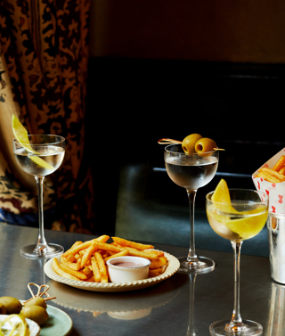 Martini Hour at Brasserie Max. A portrait shot of a table of martinis and fries on a table