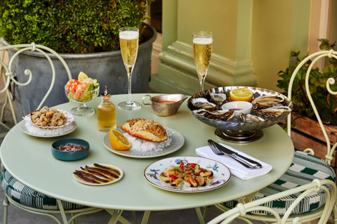 Multiple seafood dishes shot on the patio at Charlotte Street Hotel. Including Oysters, Crab, other seafood dishes and glasses of champagne.
