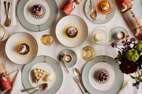 An image from above of the dessert on offer from the Christmas Day menu at Ham Yard restaurant, Ham Yard Hotel. In the image you can see Ham Yard Christmas pudding, brandy sauce and brandy butter, Chestnut and blackberry roulade, Sticky date and Earl Grey tart, bergamot ice cream, Blood orange crème caramel all on Sailors Fairwell crockery.