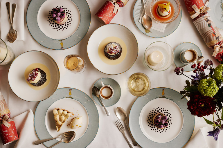 An image from above of the dessert on offer from the Christmas Day menu at Ham Yard restaurant, Ham Yard Hotel. In the image you can see Ham Yard Christmas pudding, brandy sauce and brandy butter, Chestnut and blackberry roulade, Sticky date and Earl Grey tart, bergamot ice cream, Blood orange crème caramel all on Sailors Fairwell crockery.
