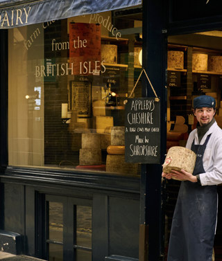 Wide shot of exterior of Neal's Yard on Monmouth street, showing a staff member standing at the entrance 
