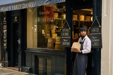 Wide shot of exterior of Neal's Yard on Monmouth street, showing a staff member standing at the entrance