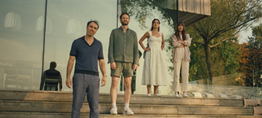 A still from the film "Splitsville": Two men and two women stand on some steps outside a house, looking out