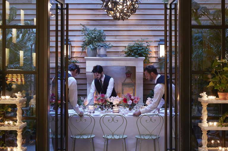Long dining tables set-up and waiters in the Orangery private events room at the Whitby Hotel