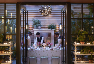 Long dining tables set-up and waiters in the Orangery private events room at the Whitby Hotel