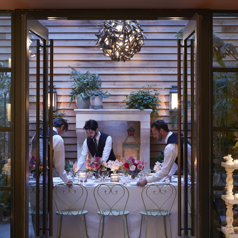 Long dining tables set-up and waiters in the Orangery private events room at the Whitby Hotel