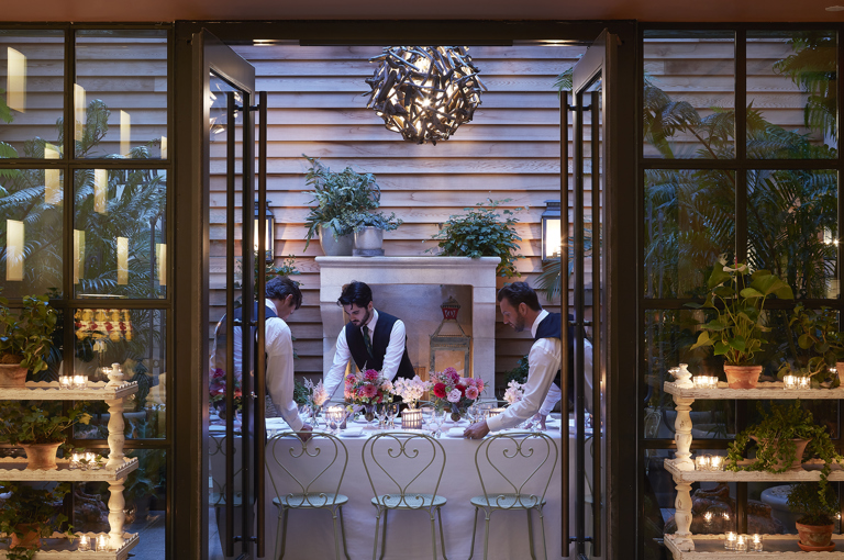 Long dining tables set-up and waiters in the Orangery private events room at the Whitby Hotel
